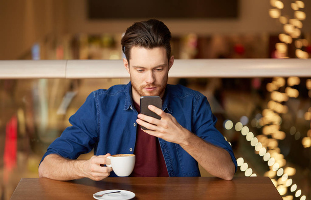 man with coffee and smartphone at restaurant - Foto, Imagen