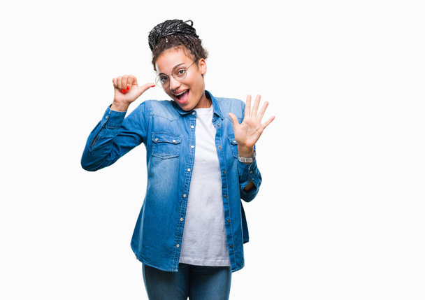 Nuori punottu hiukset afrikkalainen amerikkalainen tyttö yllään lasit yli eristetty tausta näyttää ja osoittaa ylös sormet numero kuusi hymyillen itsevarma ja onnellinen
. - Valokuva, kuva