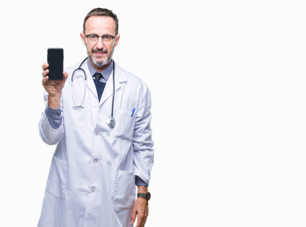 Hombre médico de edad madura hoary mostrando la pantalla del teléfono inteligente sobre un fondo aislado con una expresión de confianza en la cara inteligente pensando en serio
 - Foto, imagen
