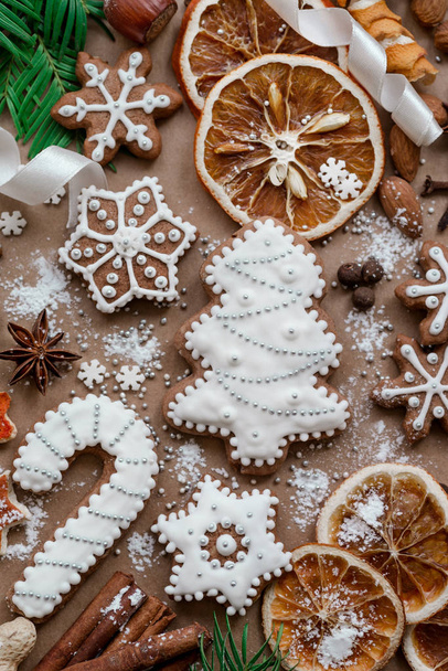 Christmas dekoration with spices and cookies in the shape of snowflakes on dark brown paper background. Top view. - Foto, Imagen