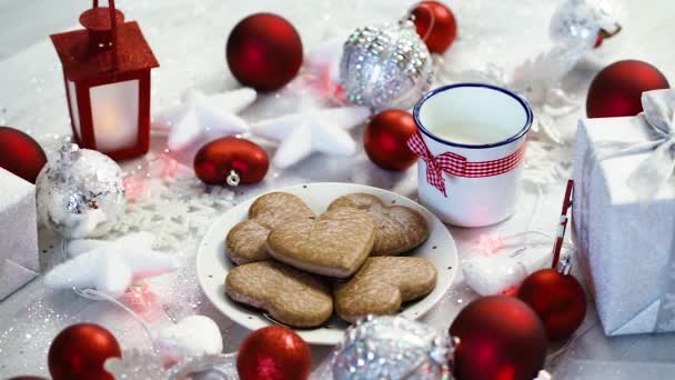 brillante decoración de Navidad con regalos de plata burbujas rojas y galletas caseras, luz roja y leche
 - Imágenes, Vídeo