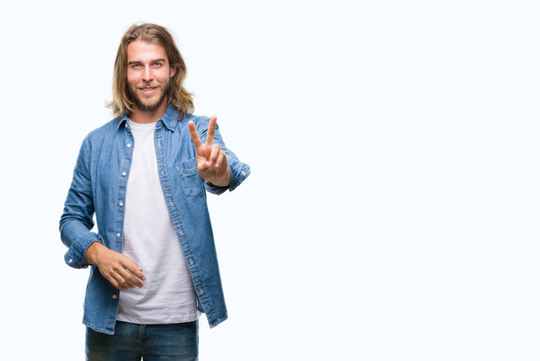 Young handsome man with long hair over isolated background smiling looking to the camera showing fingers doing victory sign. Number two. - Zdjęcie, obraz