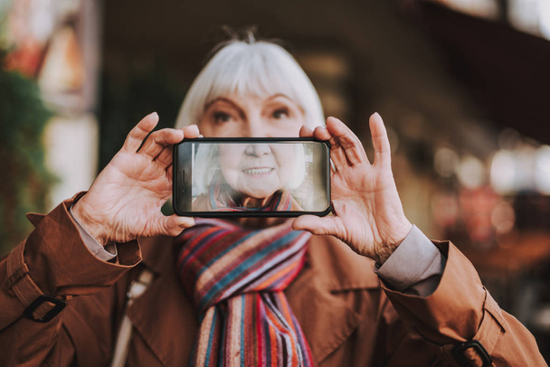 Joyful senior lady making selfie on the street - Foto, immagini