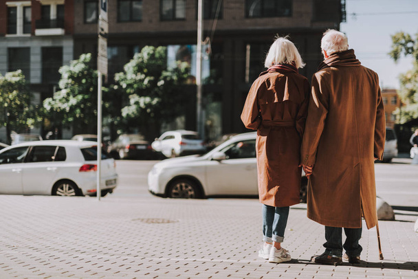 Happy senior couple holding hands on the street - Foto, afbeelding