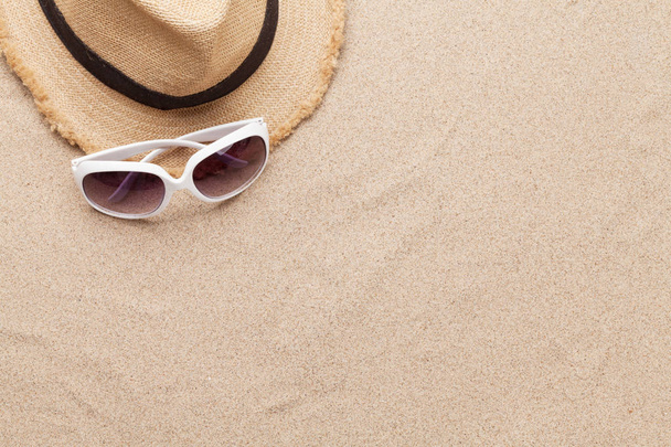 サングラスで休暇の背景の概念を旅行し、砂の背景に帽子。コピースペース付きのトップビュー。平敷 - 写真・画像