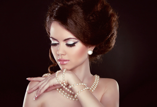 Beautiful pretty woman with pearls on her neck isolated on dark - Fotografie, Obrázek