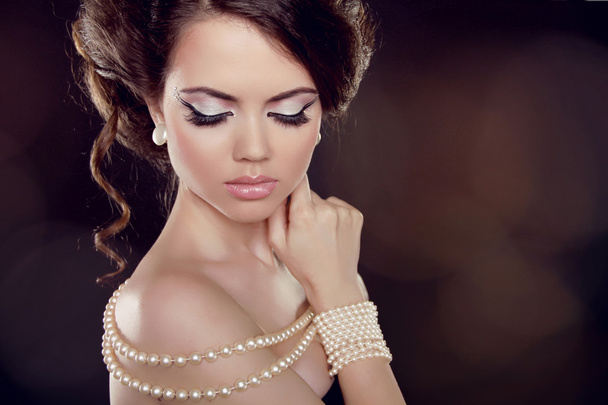 Fashion woman with a pearl necklace on the bared shoulders - Фото, зображення