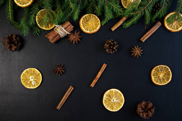 Christmas Tree Pine Branches with dry oranges. cinnamon, anise on a dark background. - 写真・画像