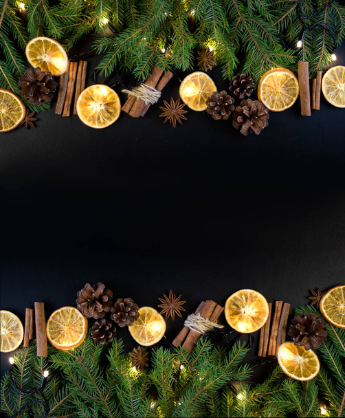 Christmas Tree Pine Branches with dry oranges. cinnamon, anise on a dark background. - Photo, Image