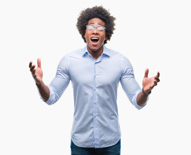 Afro Amerikaanse zakenman bril geïsoleerd achtergrond vieren gek en verbaasd voor succes met armen verhoogd en open ogen schreeuwen opgewonden. Winnaar concept - Foto, afbeelding