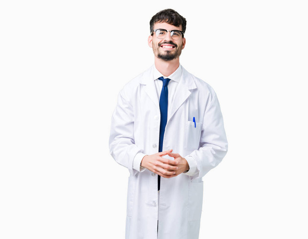 Fiatal szakmai tudós ember visel fehér kabát-felső kezét elszigetelt háttér együtt és az ujjak keresztezett, mosolygós, nyugodt és vidám. Sikeres és optimista - Fotó, kép