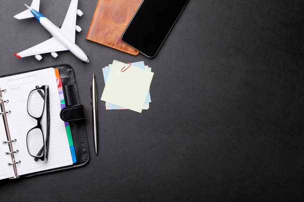 Business trip concept. Accessories on desk table. Glasses, passport, notepad, smartphone and airplane toy. Top view with copy space - Photo, Image