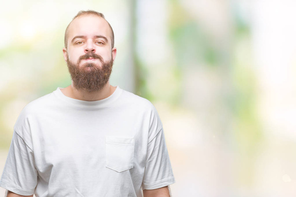 Young caucasian hipster man wearing casual t-shirt over isolated background puffing cheeks with funny face. Mouth inflated with air, crazy expression. - Fotografie, Obrázek