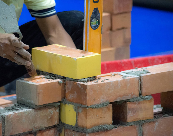 Bricklayer asentamalla tiilet, Bricklayer työntekijä asentamalla tiili muuraus ulkoseinään lastalla kitti knif
 - Valokuva, kuva