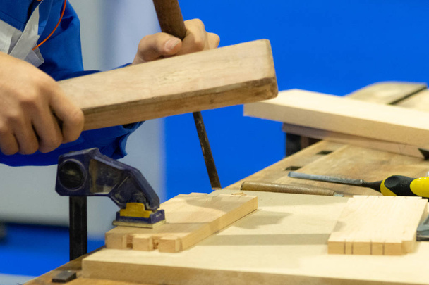 Плотник с зубилом и молотком в мастерской, близко
 - Фото, изображение