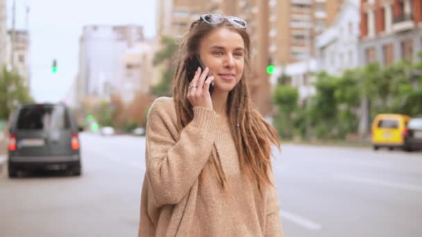 νεαρή γυναίκα χρήση κινητού σε εξωτερικούς χώρους - Πλάνα, βίντεο