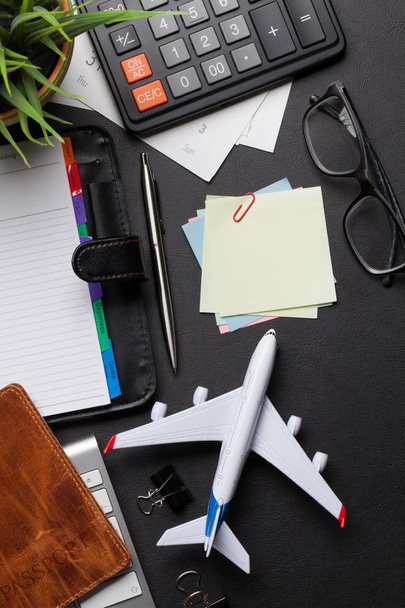 Business trip concept. Accessories on desk table. Pc keyboard, passport, calendar and airplane toy. Top view with copy space - Photo, image