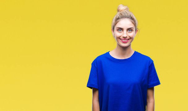 Young beautiful blonde and blue eyes woman wearing blue t-shirt over isolated background with a happy and cool smile on face. Lucky person. - Foto, Bild
