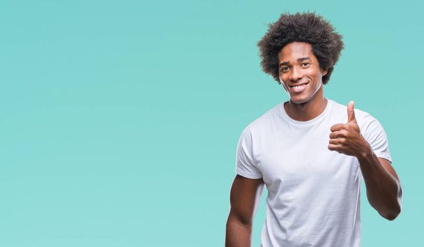 Afro american man over isolated background doing happy thumbs up gesture with hand. Approving expression looking at the camera with showing success. - Photo, Image