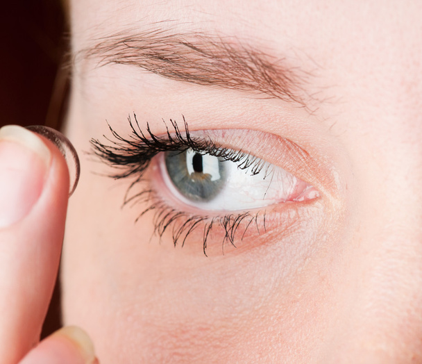 Close up of inserting a contact lens in female eye - Photo, image