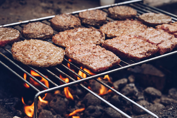 Close-up of delicious hamburger meat being grilled on barbecue outdoors - 写真・画像
