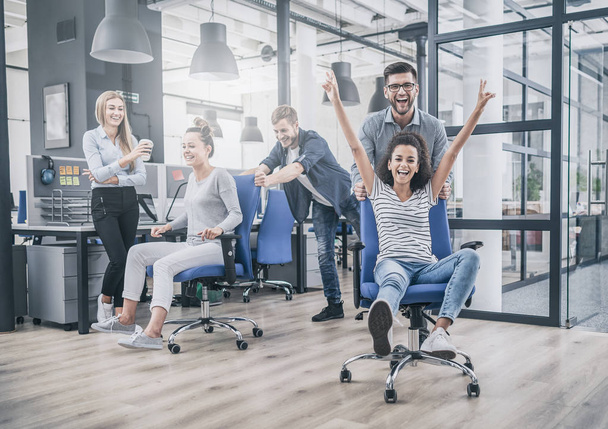 Happy business team dressed in casual clothing having fun in modern office.  - Photo, Image