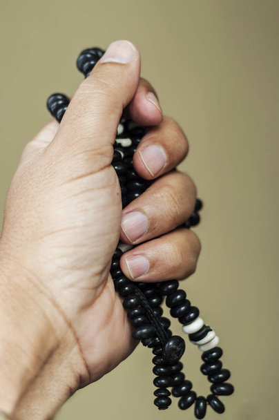 male hands praying holding a rosary - Photo, Image