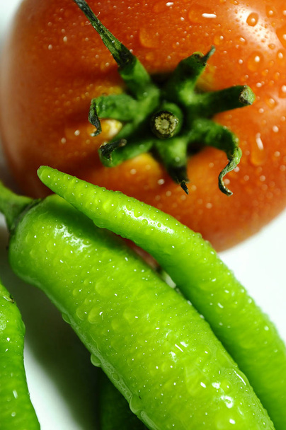 Bijgesneden weergave van tomaat met groene peper - Foto, afbeelding