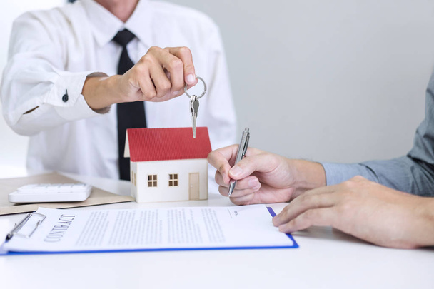 Real estate Sales manager giving keys to customer after signing rental lease contract of sale purchase agreement, concerning mortgage loan offer for and house insurance. - Φωτογραφία, εικόνα