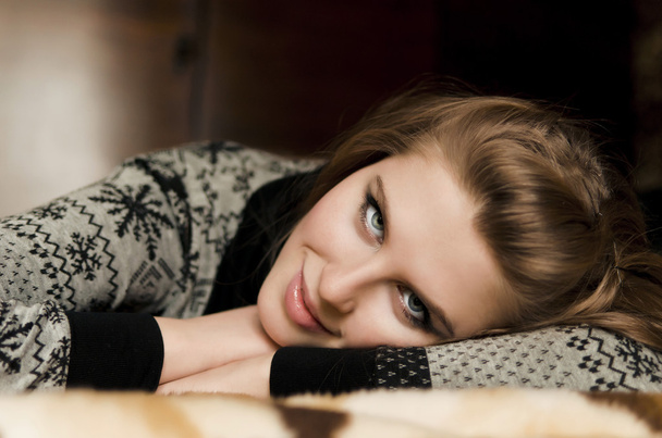 Une jolie jeune femme allongée sur ses bras sur le canapé
 - Photo, image