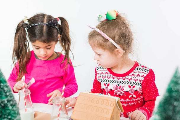 Kinderen versieren kleine ontbijtkoek tijdens de kerst huizen ambachtelijke partij. - Foto, afbeelding