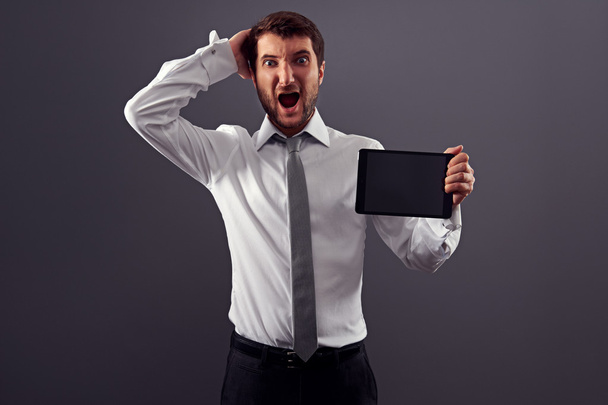 σοκαρισμένος άνθρωπος που κρατά tablet pc και ουρλιάζοντας - Φωτογραφία, εικόνα