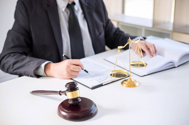 Male lawyer or judge working with Law books, gavel, report the case on table in modern office, Law and justice concept. - 写真・画像