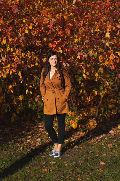 Portrait of young urban style woman standing at park. Autumn season. - Fotoğraf, Görsel