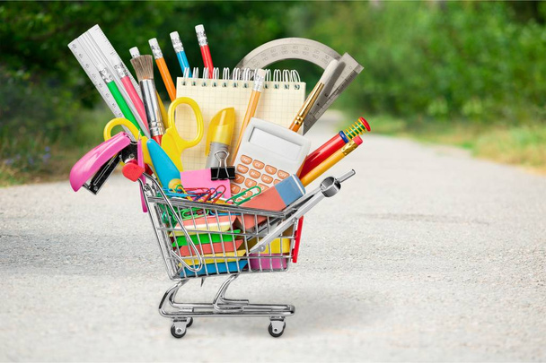 Shopping cart with colorful school stationery, back to school background - Фото, зображення