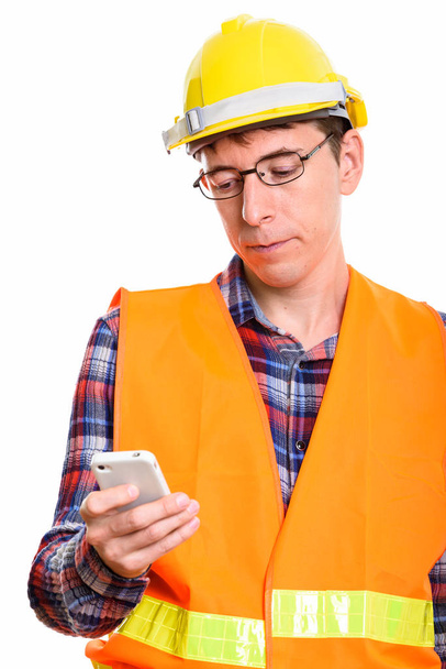Студийный снимок человека строителя с помощью мобильного телефона
 - Фото, изображение