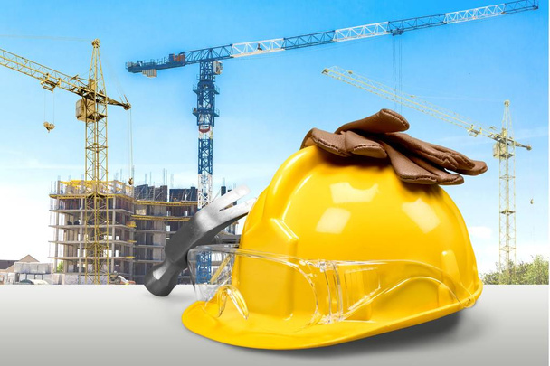 Gele helm en hulpprogramma's op de bouwplaats - Foto, afbeelding