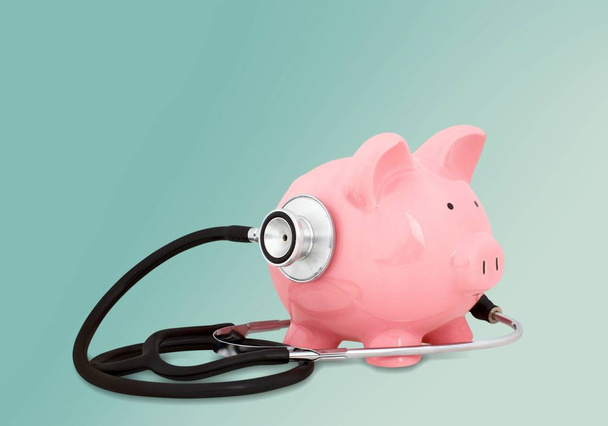Piggy bank with medical stethoscope, health insurance concept - Foto, afbeelding