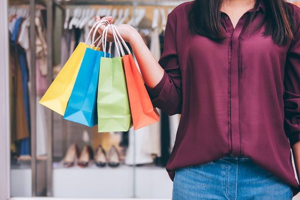 Consumerism, shopping lifestyle concept, Young woman standing and holding colorful shopping bags enjoying in shopping. - Foto, imagen