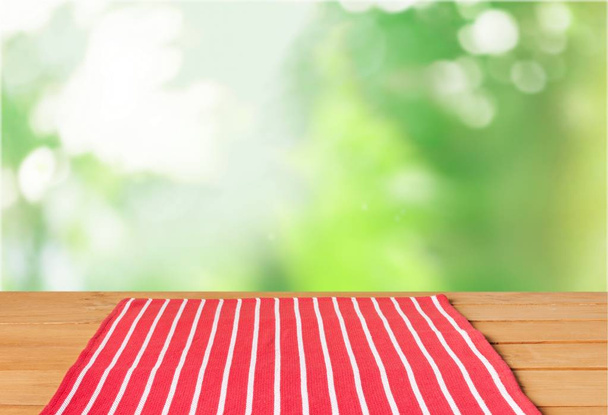 木製のテーブルの赤い縞模様のテーブルクロス - 写真・画像