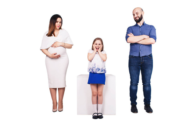 felice giovane famiglia isolata su sfondo bianco. Barbuto padre, madre incinta e figlia felice
. - Foto, immagini