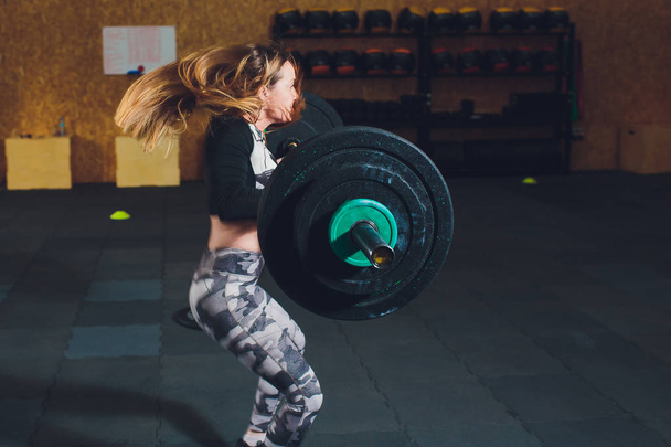 Attractive young sports woman with barbell. Deadlift. - Foto, Bild
