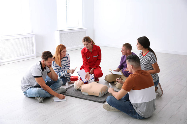 Grupo de personas con instructor en la clase de primeros auxilios en interiores
 - Foto, imagen