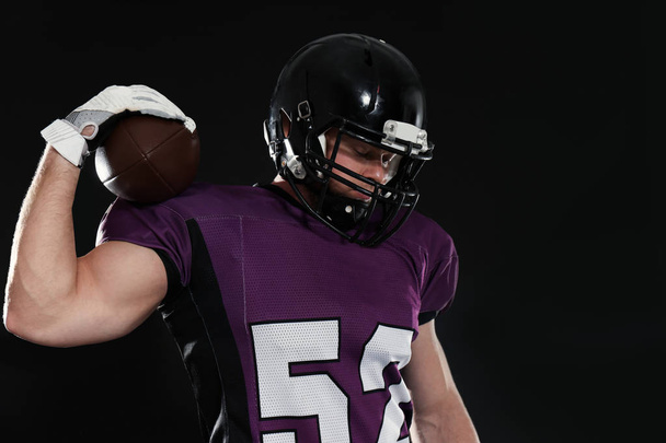 American football player with ball on dark background - Photo, image