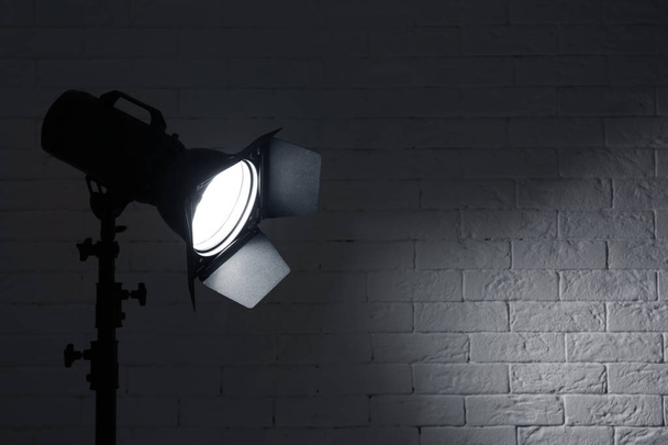Equipo profesional de iluminación de estudio fotográfico cerca de pared de ladrillo. Espacio para texto
 - Foto, imagen
