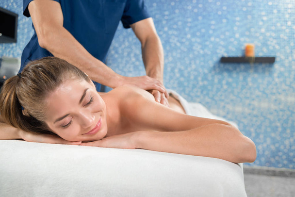 Enfoque selectivo de la mujer sonriente durante el procedimiento de masaje
 - Foto, Imagen