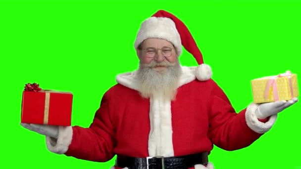 Santa s dárky na zelené obrazovce. Staré autentické Santa Claus drží vánoční dárkové krabičky v obou rukou. Zelené barvy pozadí pro klíčování. - Záběry, video