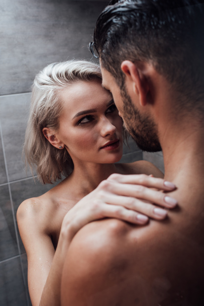 beautiful young woman passionately looking at man in shower  - Foto, Imagem