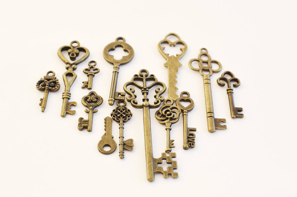 Decorative keys of different sizes, stylized antique on a white background. Form the centerpiece. - Fotografie, Obrázek