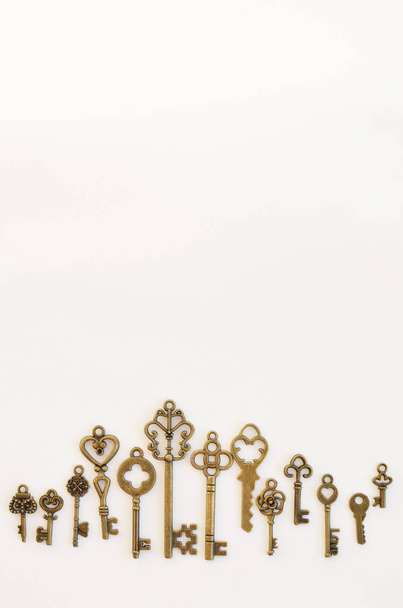Decorative keys of different sizes, stylized antique on a white background. Located on the bottom edge. - Photo, Image